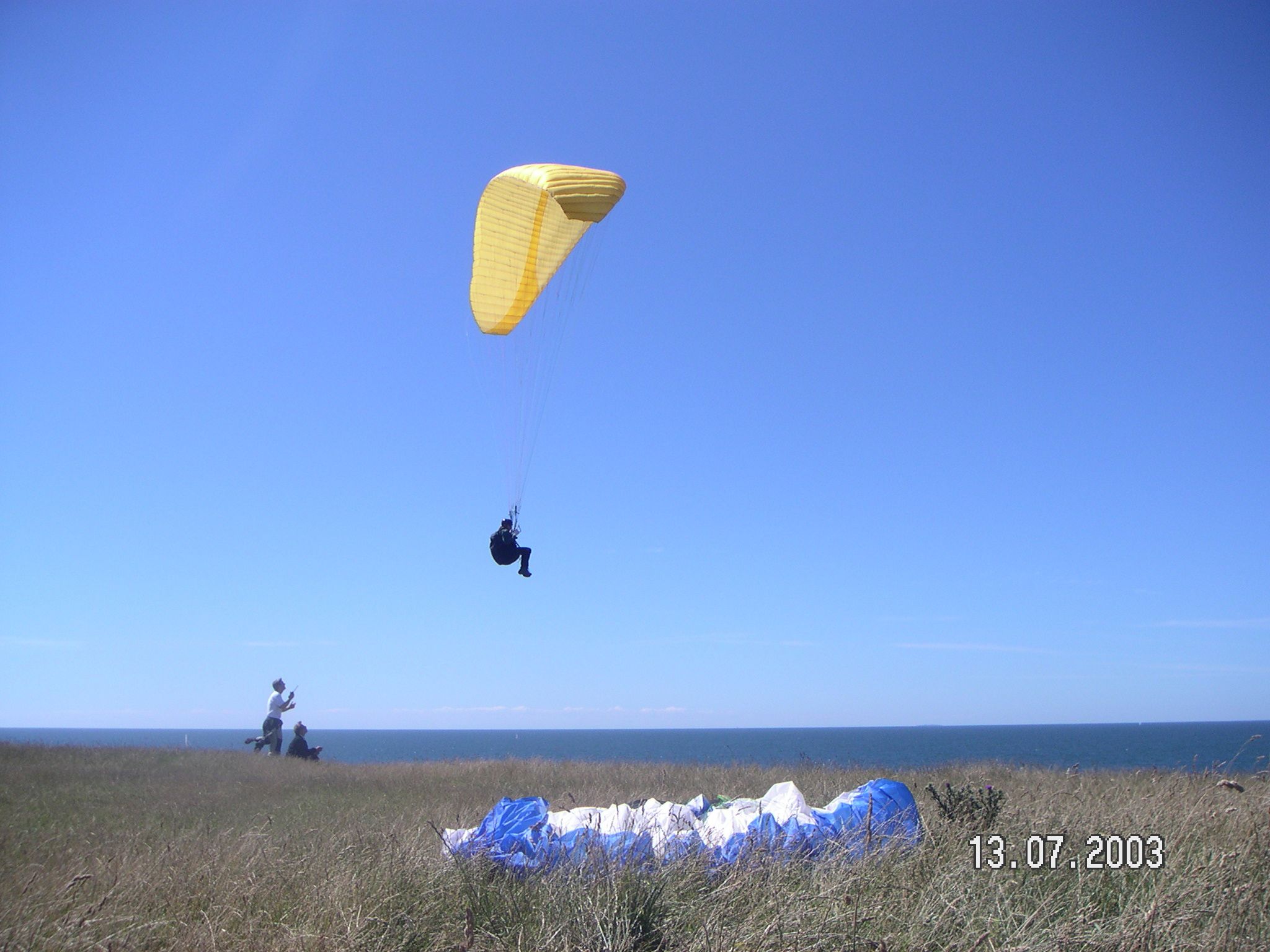 mand lander i faldskærm på mark