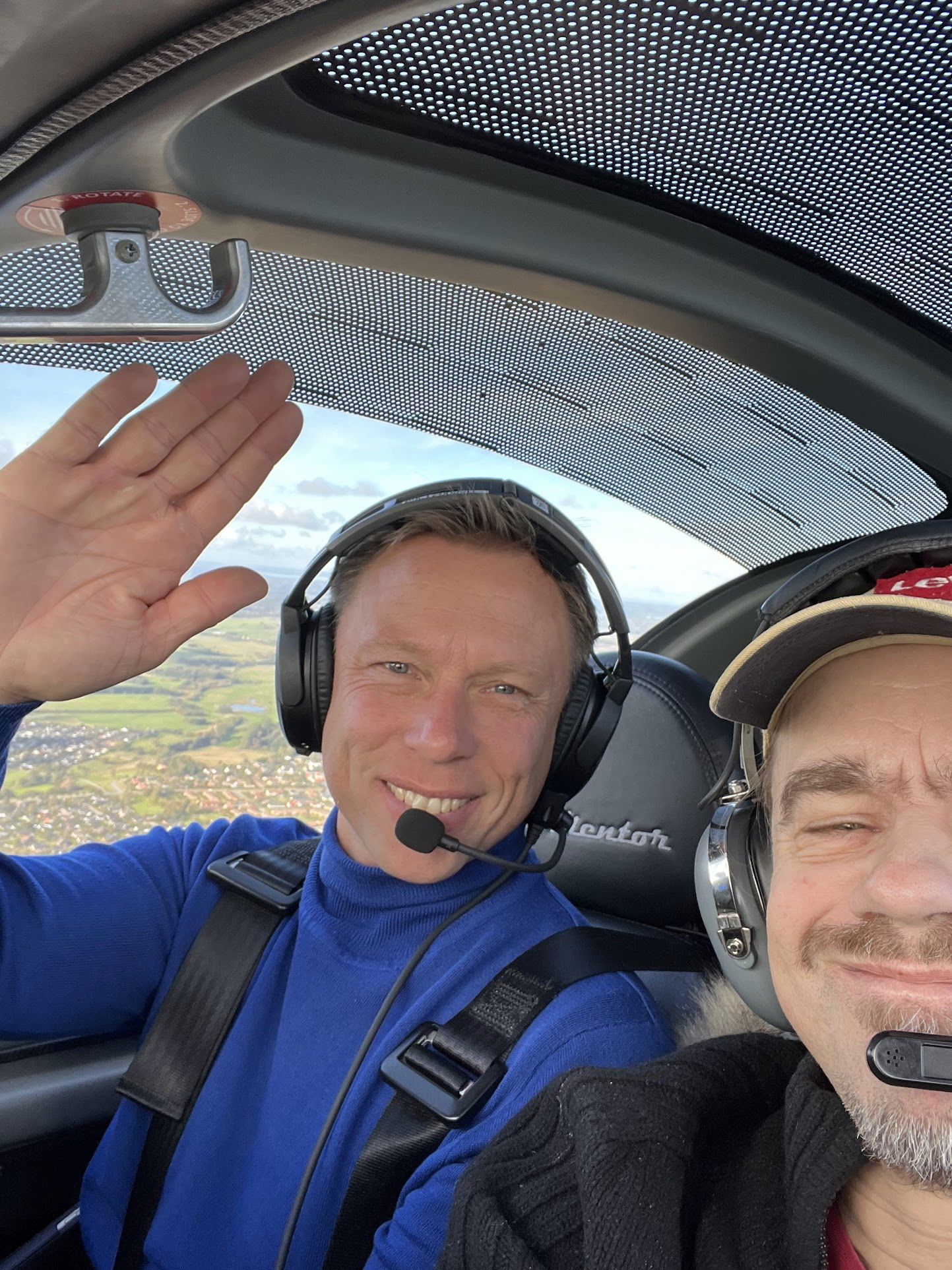 to mænd hilser fra cockpit af lille fly